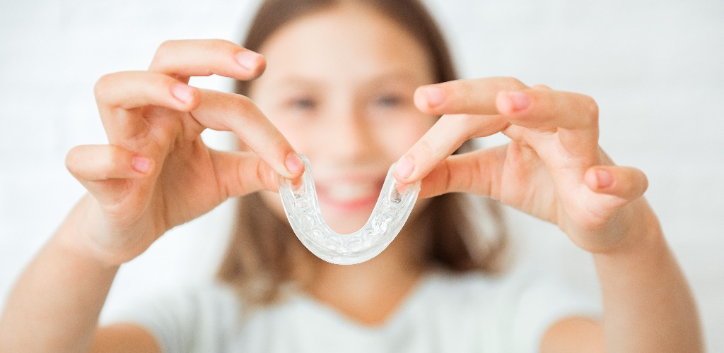 Smiling child girl with healthy teeth using removable braces or aligner for straightening and whitening teeth orthodontic treatment for correction of bite jpg