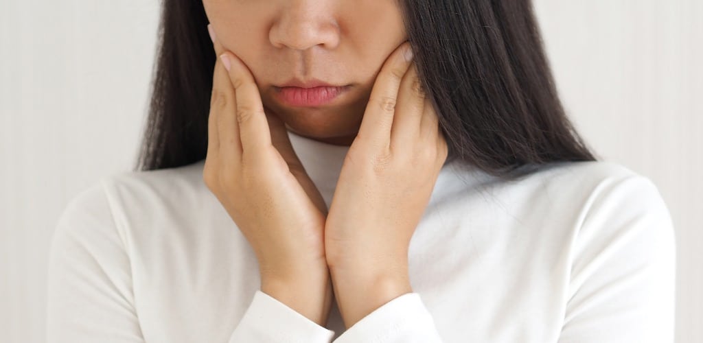 trigeminal neuralgia and temporomandibular joint and muscle disorder in asian woman, She use hand touching her cheek and symptoms fo pain and suffering on isoleted white background.