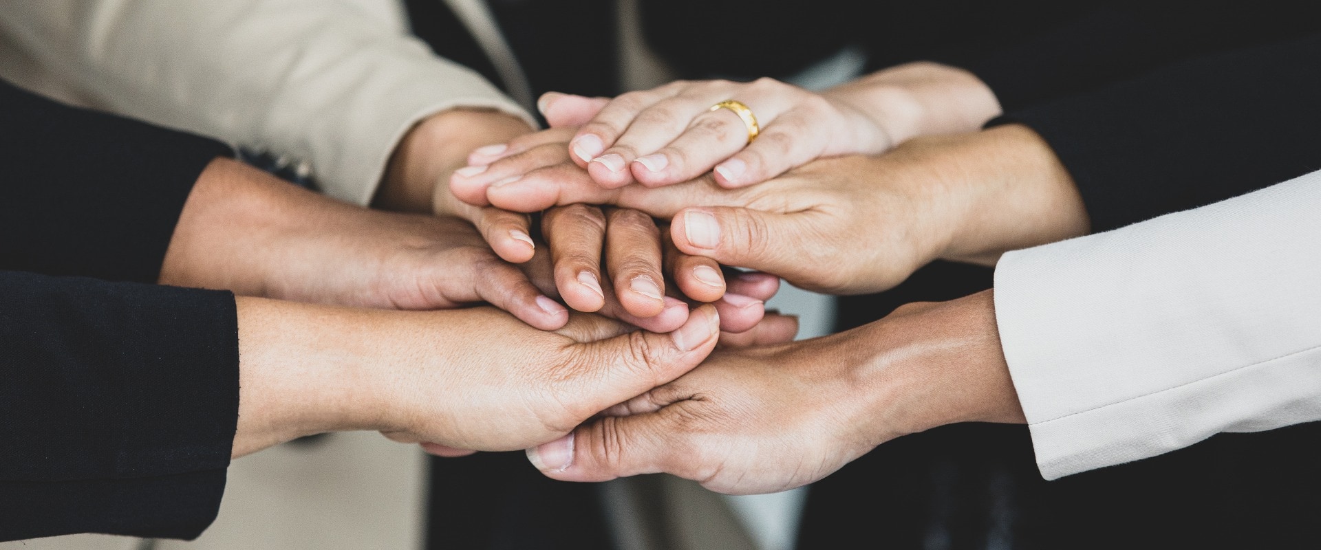 Close up shot of holding hands of unidentified unrecognizable successful female businesswoman group together in formal business suit wears empower encourage as trust teamwork partnership agreement